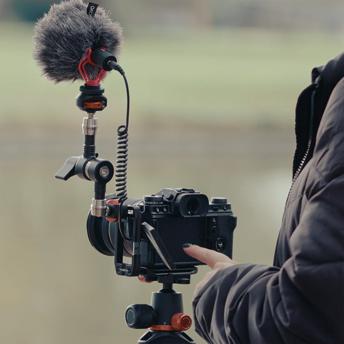 Camera with microphone on a tripod in an outdoor setting