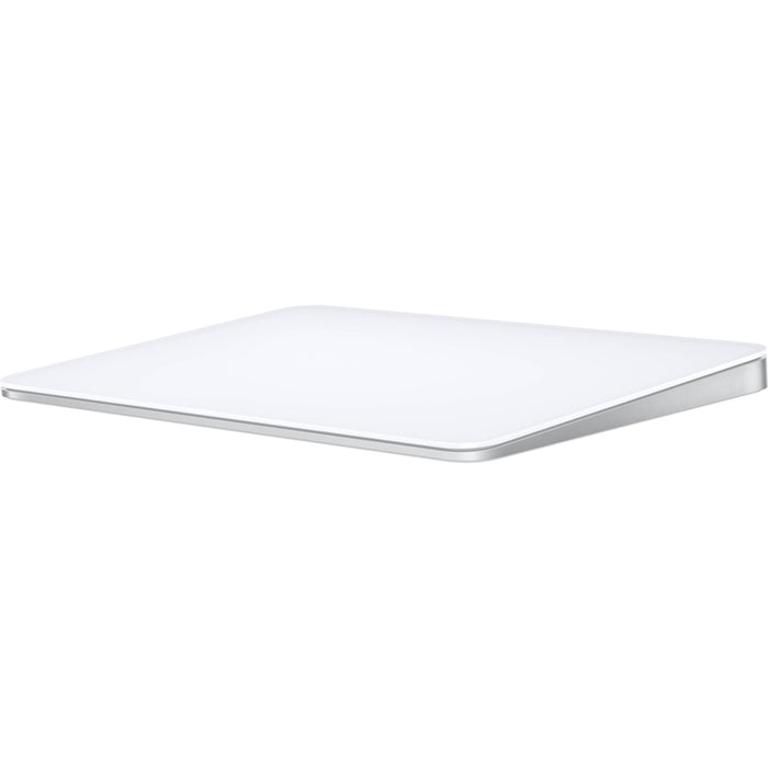 A sleek, white Apple Magic Trackpad with a large edge-to-edge glass surface and a low-profile ergonomic tilt, shown from a three-quarter perspective.