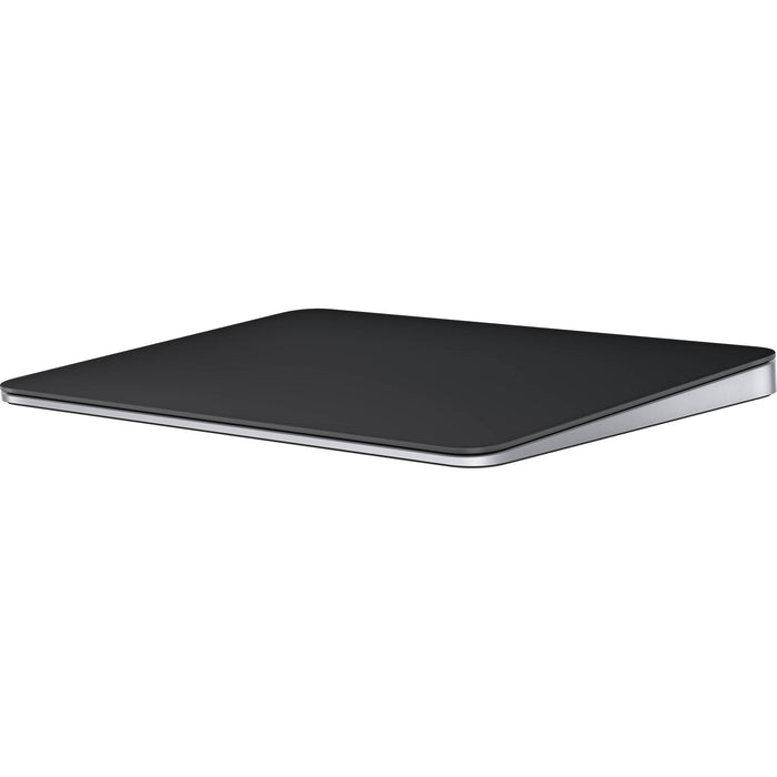 A sleek, black Apple Magic Trackpad with a large edge-to-edge glass surface and a low-profile ergonomic tilt, shown from a three-quarter perspective.