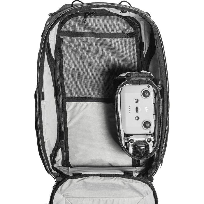 Black handheld Peak Design Camera Cube V2 with adjustable dividers, zipper closure, and durable nylon exterior, perfect for carrying camera gear safely.