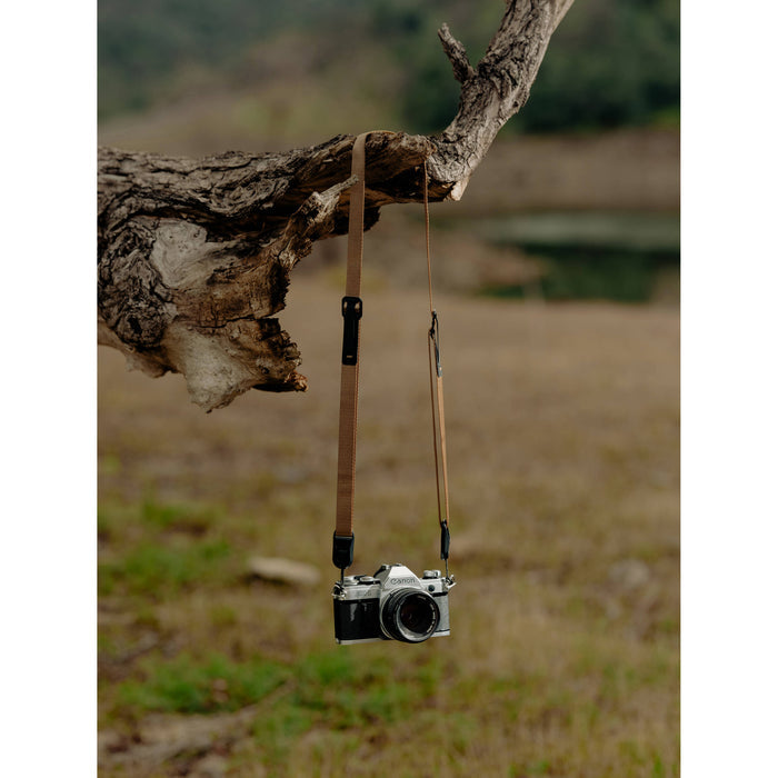Peak Design Leash camera strap in Coyote color, adjustable length 83-145 cm, ultralight nylon webbing with leather accents, quick-release anchors rated for 90kg, versatile for sling, neck, shoulder, or cross-body use.